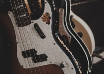 brown and black bass guitars