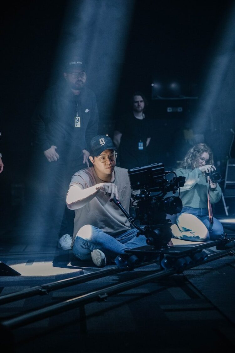 a man sitting on the ground in front of a camera