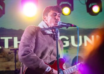 a man that is standing up with a guitar