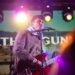 a man that is standing up with a guitar