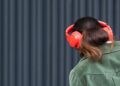 a woman wearing red headphones and a green jacket