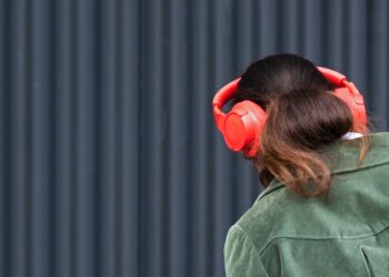 a woman wearing red headphones and a green jacket