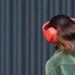 a woman wearing red headphones and a green jacket